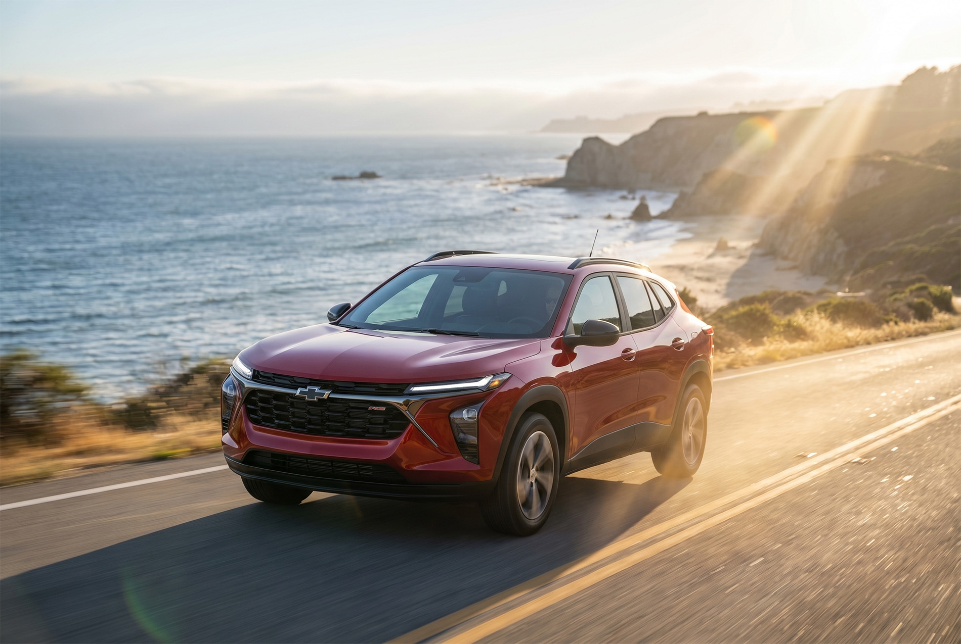 A red 2026 Chevrolet Trax driving along the Pacific Ocean in Northern California