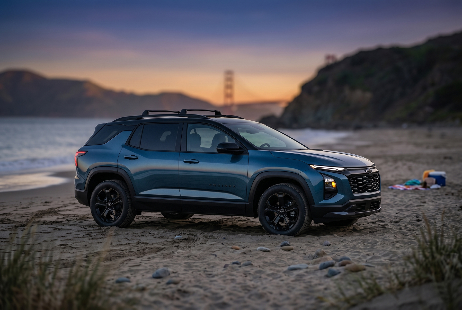 A dark blue 2026 Chevrolet Equinox LT parked on a California beach at sunset