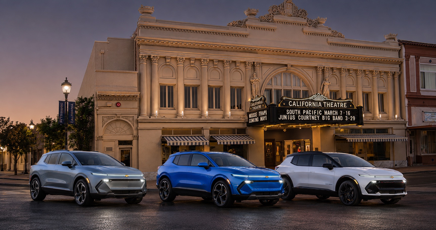 Three Chevrolet Equinox EV SUVs in silver blue and white parked in front of California Theatre at dusk showcasing full trim range and color options.